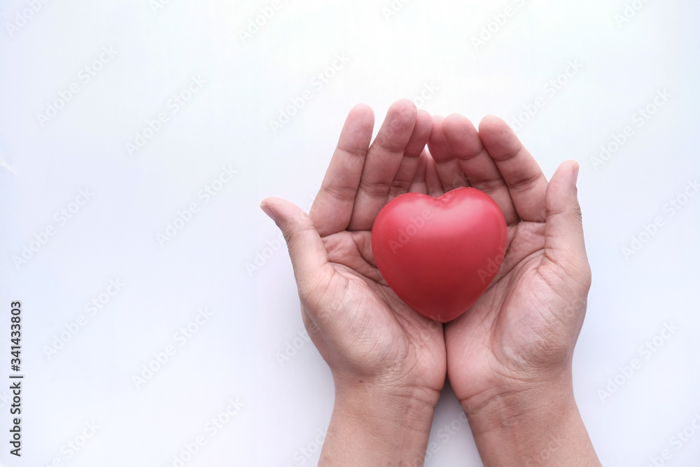 woman holding red heart in hands on wooden table . woman holding red heart in hands on wooden table .