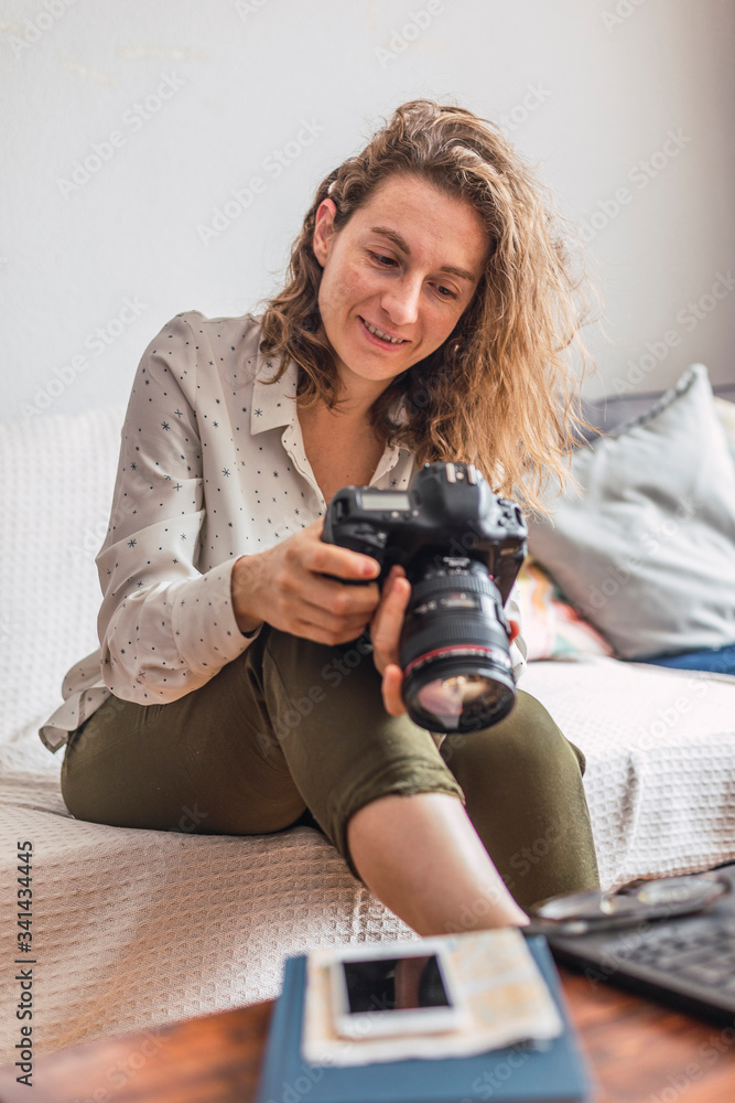 smiling female photographer edits her photographs at home