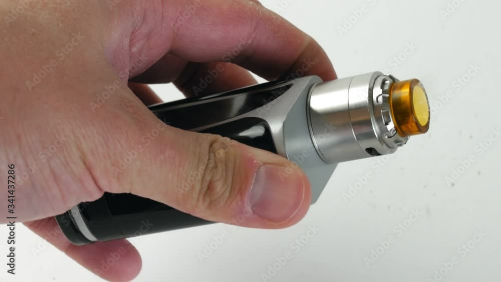 Man holds an electronic cigarette in his hand on a white background.
