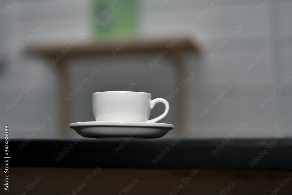 White cup of espresso coffee on a dark blurred background. Selective focus.