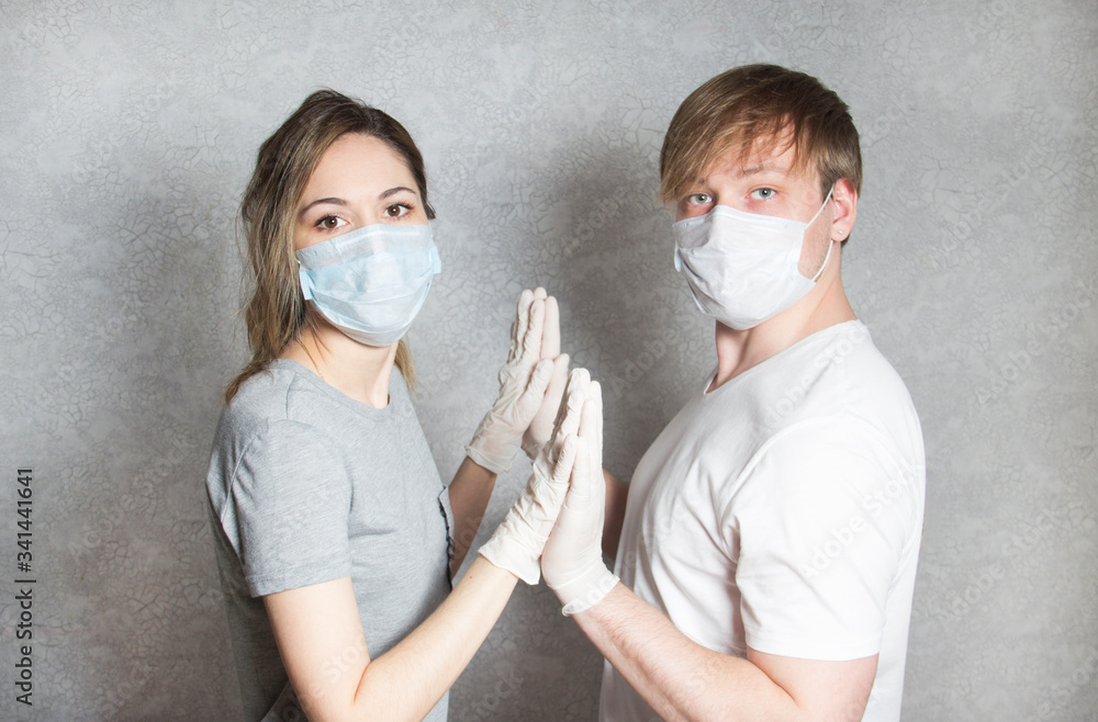 a man and a woman in rubber gloves and medical masks hold hands. OKVED-19