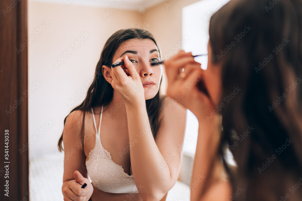 Young beautiful sexy girl makes a make-up in front of a mirror, always beautiful, spring time Young beautiful sexy girl makes a make-up in front of a mirror, always beautiful, spring time