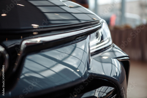 Closeup of a car headlight. Headlight of an expensive new car at a car dealership.