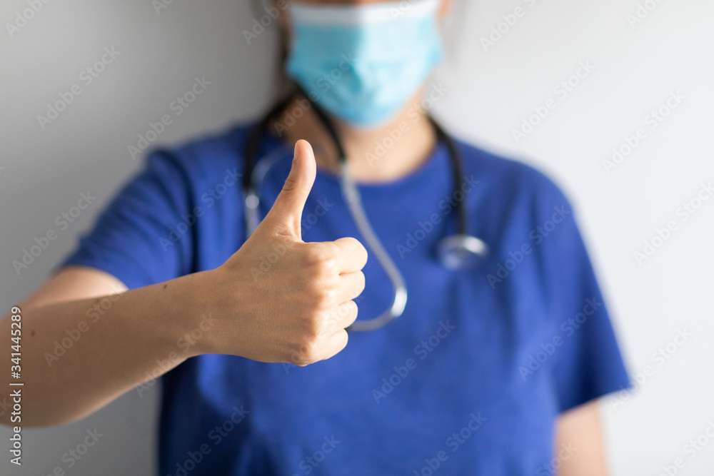 Doctor with mask shows thumb up, sign that everything is fine, of approval Doctor with mask shows thumb up, sign that everything is fine, of approval