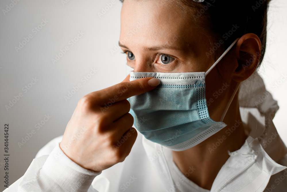 portrait of young woman which correct her mask over white background portrait of young woman which correct her mask over white background