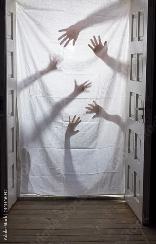 Hand silhouette. Mystical hands behind the door. photo