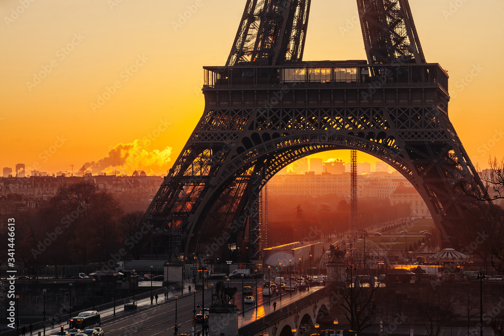 Fototapeta premium The foot of the Eiffel Tower against the backdrop of the rising sun. Tower silhouette at dawn.