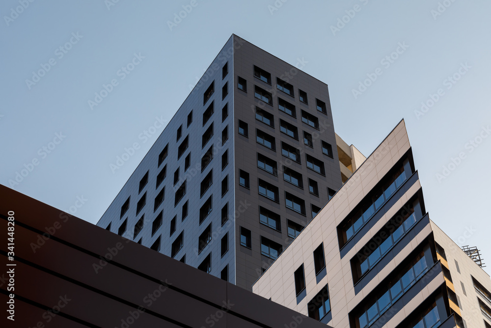 Fagment of a new elite residential building or commercial complex. Part of urban real estate. Black modern ventilated facade with windows. Fagment of a new elite residential building or commercial complex. Part of urban real estate. Black modern ventilated facade with windows.