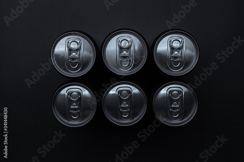 Set of aluminum cans on dark background, top view.