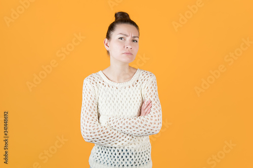 girl folded her arms over her chest and looks condemning photo