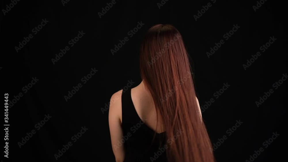 young woman in studio on a black background with flying hair young woman in studio on a black background with flying hair