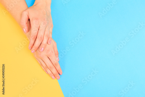 female  manicure. Beautiful young woman s hands on pastel color  background - Image
