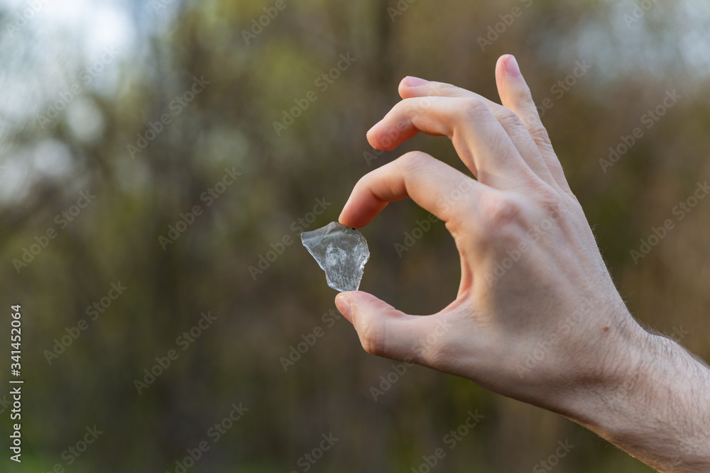 piece of broken glass in hand close up