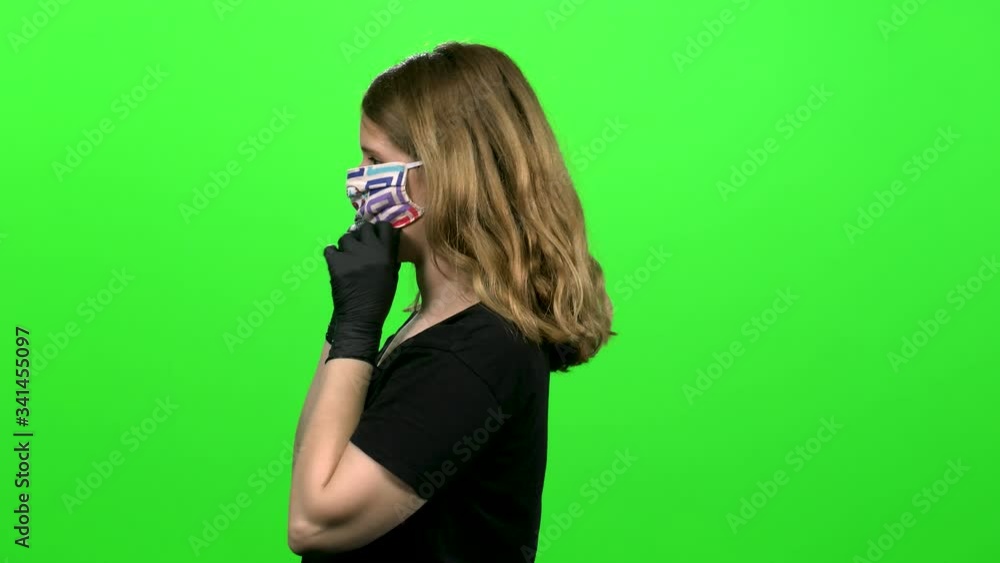 Woman demonstrating the use of a protecting mask: Putting on, coughing and sneezing, using surgical gloves. Medium shot over green screen. Woman demonstrating the use of a protecting mask: Putting on, coughing and sneezing, using surgical gloves. Medium shot over green screen.