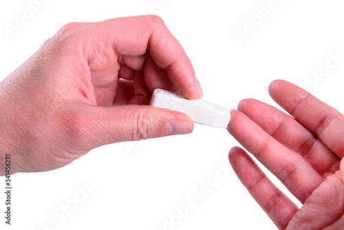 Blood test woman taking blood sample using lancet on finger closeup isolated on white