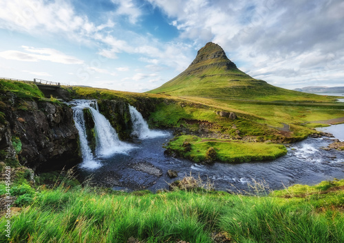 Kirkjufell mountain and waterfall in the Iceland. Natural landscape in the summer. Grass and river. Famous place. Iceland travel - image