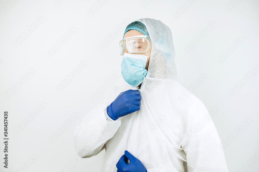 portrait of tired doctor after shift in the hospital. The doctor in protective clothing - glasses, mask, gloves on white background. The doctor treating patients with coronavirus. Covid-2019 portrait of tired doctor after shift in the hospital. The doctor in protective clothing - glasses, mask, gloves on white background. The doctor treating patients with coronavirus. Covid-2019