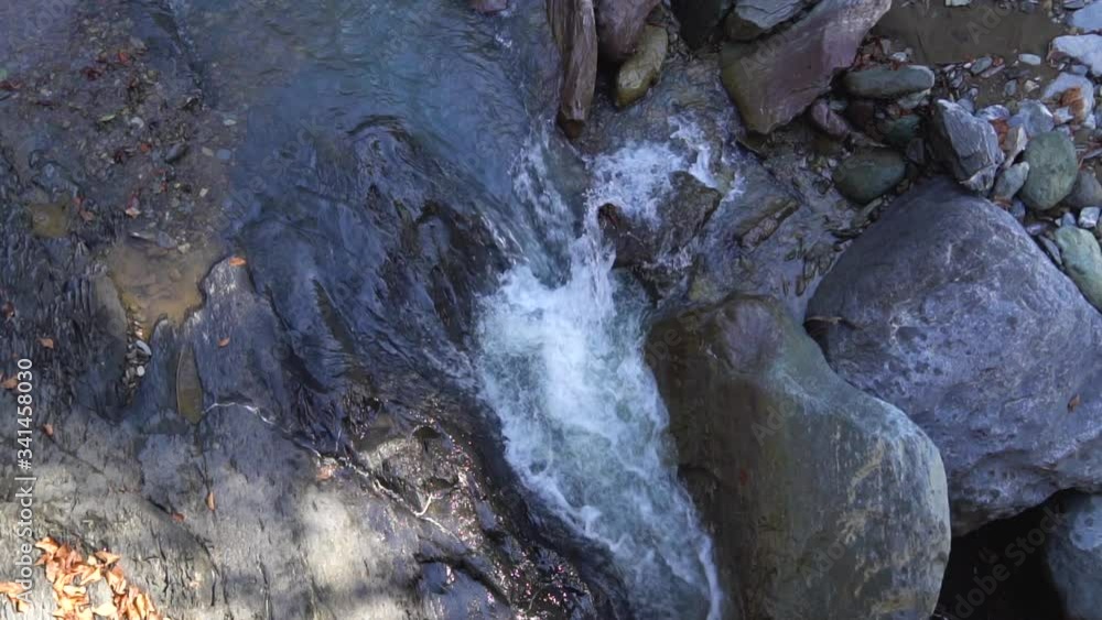 Scenic waterfall flows through the forest in the mountains. Slow motion Scenic waterfall flows through the forest in the mountains. Slow motion
