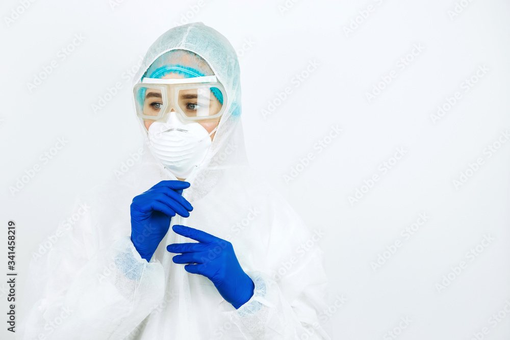 portrait of tired doctor after shift in the hospital. The doctor in protective clothing - glasses, mask, gloves on white background. The doctor treating patients with coronavirus. Covid-2019 portrait of tired doctor after shift in the hospital. The doctor in protective clothing - glasses, mask, gloves on white background. The doctor treating patients with coronavirus. Covid-2019