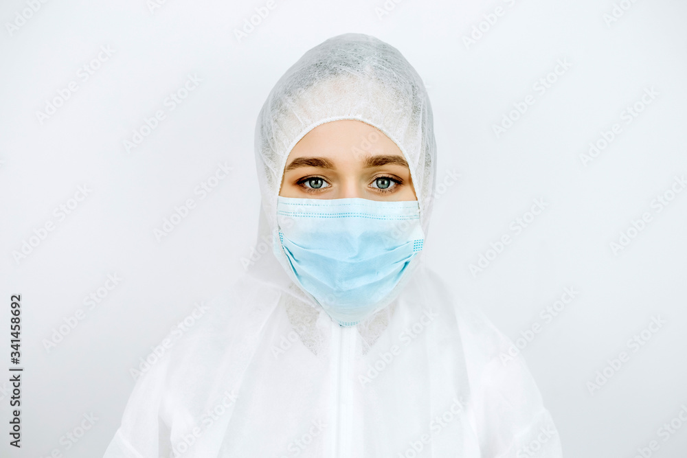 portrait of tired doctor after shift in the hospital. The doctor in protective clothing - glasses, mask, gloves on white background. The doctor treating patients with coronavirus. Covid-2019 portrait of tired doctor after shift in the hospital. The doctor in protective clothing - glasses, mask, gloves on white background. The doctor treating patients with coronavirus. Covid-2019