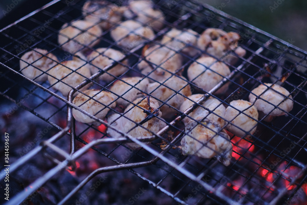Grilled marinated mushrooms. Smoke and charcoal heat. Evening time