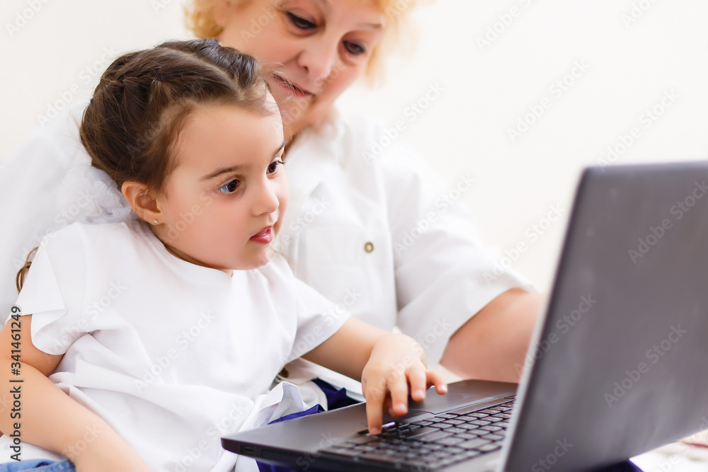 little girl and grandmother learning online on laptop little girl and grandmother learning online on laptop