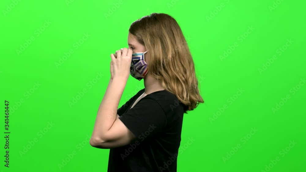 Happy Woman demonstrating the use of a protecting mask: Putting on, coughing and sneezing. Medium shot over green screen. Happy Woman demonstrating the use of a protecting mask: Putting on, coughing and sneezing. Medium shot over green screen.
