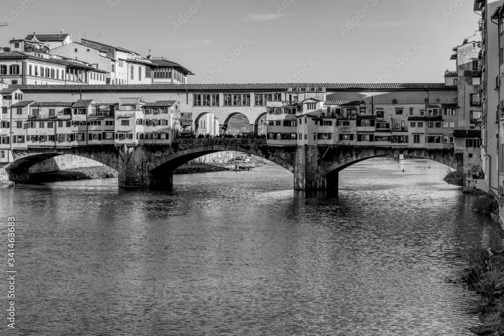 A black and white of Ponte Vecchio in Florence, Italy.  In a sunny day with no clouds.