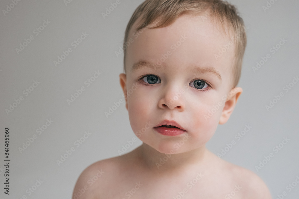 baby boy caucasian toddler in a white studio. Emotions of the kid, a sad, pensive look. Close up portrait of a child. baby boy caucasian toddler in a white studio. Emotions of the kid, a sad, pensive look. Close up portrait of a child.