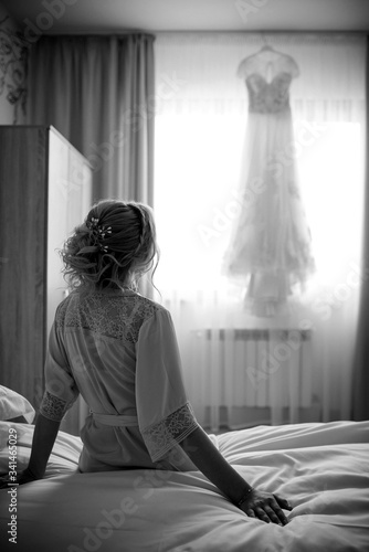 bride and wedding dress in a room by the window.