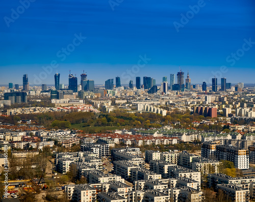 Beautiful panoramic aerial cityscape - view from the window of the plane landing at the center of Warsaw  Poland  with skyscrapers  with parks and residential areas  spring at sunset