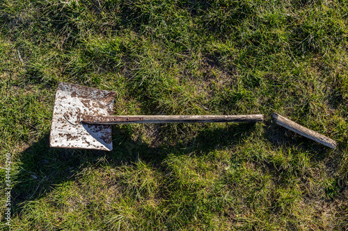 Broken spade on grass in the garden