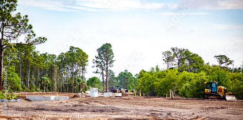 A new road is seen under construction, with various construction and earth moving equipment nearby