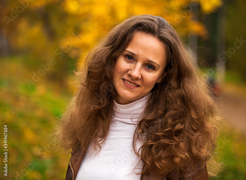 Portrait of a young beautiful girl in autumn park