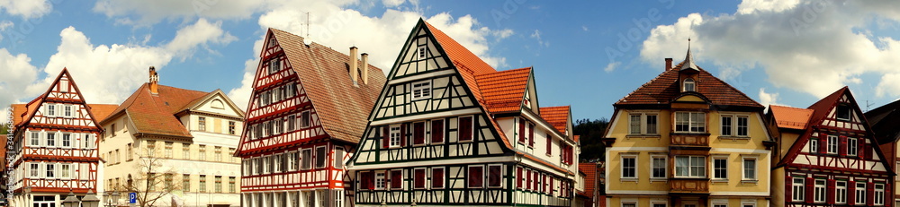 Fototapeta premium weites Panorama der Fachwerkhäuser von Calw im Schwarzwald unter blauem Himmel mit weißen Wolken