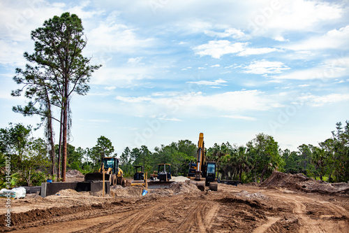 A new road is seen under construction, with various construction and earth moving equipment nearby