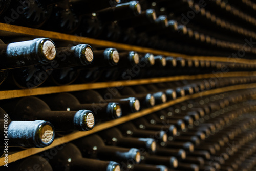 Red wine bottles stored in a wine cellar of a winery photo