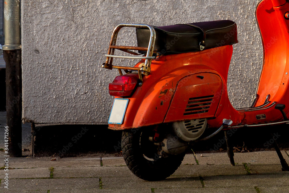 Fototapeta premium orange scooter on wall background