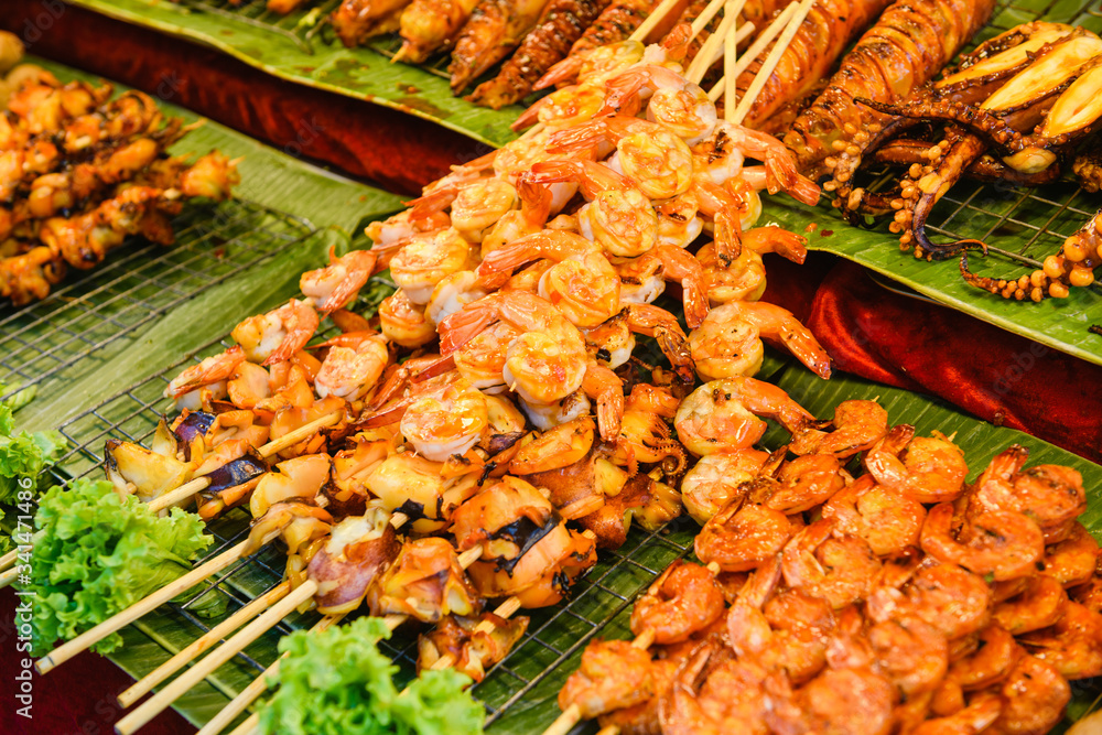 Grilled seafood on wooden skewers close up