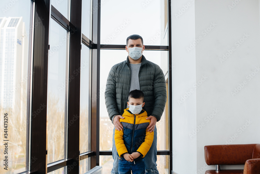 A father with his child stands in a mask during the quarantine. Pandemic, coronavirus