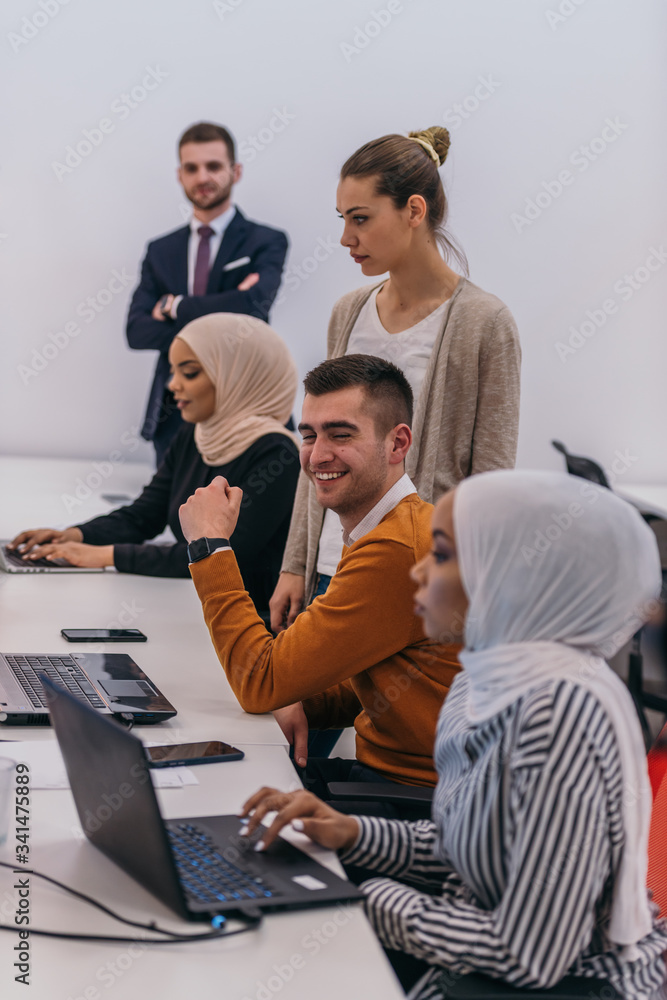Young business colleagues working together on a computer in a comfortable office atmosphere. Young business colleagues working together on a computer in a comfortable office atmosphere.