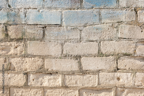 old grey brickwall texture with blue paint brughstrokes on it