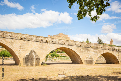 the Puente de los Austrias (Felipe IV) bridge with a view to the castle in Medellin, comarca de Vegas Altas, province of Badajoz, Extremadura, Spain photo