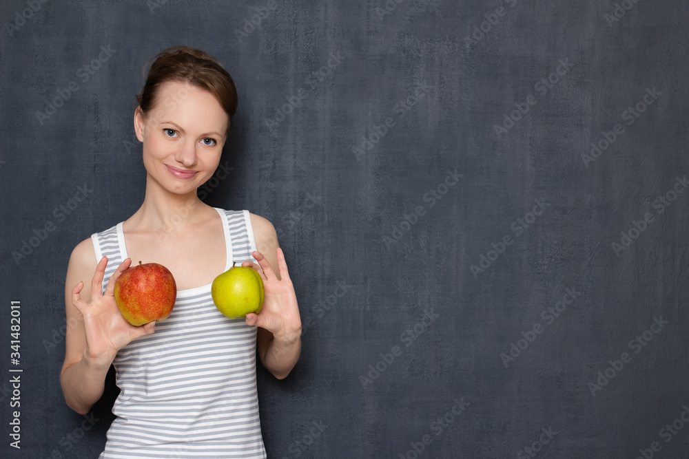Portrait of cheerful young woman holding apples in hands over chest Portrait of cheerful young woman holding apples in hands over chest
