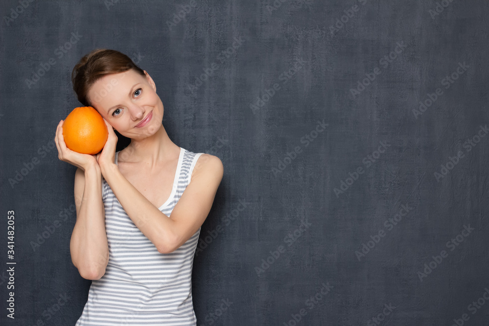 Portrait of happy girl holding ripe grapefruit in hands and smiling Portrait of happy girl holding ripe grapefruit in hands and smiling