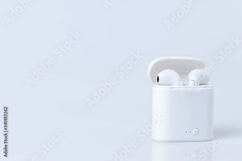 Wireless Bluetooth headphones and charging case. White headphones wireless earphones. Bluetooth earphones for new modern phone.