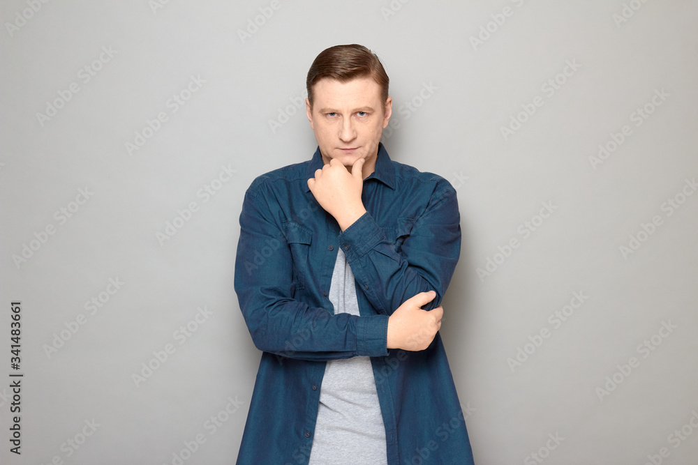Portrait of serious focused thoughtful man touching chin with one hand Portrait of serious focused thoughtful man touching chin with one hand