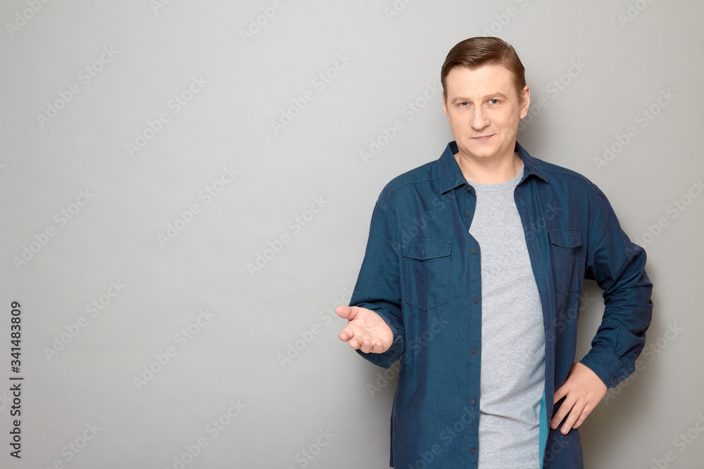 Portrait of confident friendly man stretching one hand and smiling Portrait of confident friendly man stretching one hand and smiling