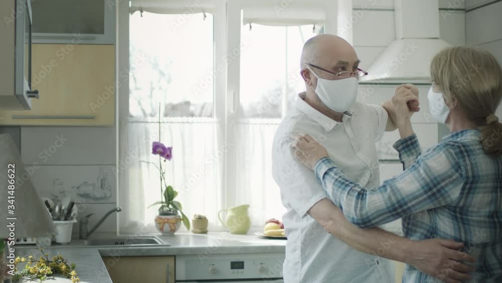 Man And Woman In Medical Masks Dancing In The Kitchen. Man And Woman In Medical Masks Dancing In The Kitchen.