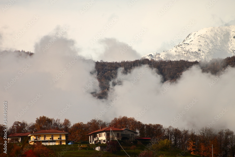 autumn mood in a mountain village between mist and snow